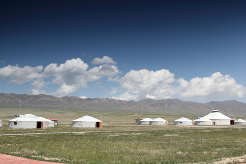 湖畔林茂涧清，草深花繁，辽阔的草原上，毡房星点。