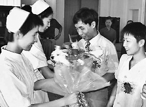 2002年7月，医护人员献上鲜花，表达新婚祝福。  